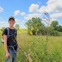 Sarah Nizzi standing in a prairie on a sunny day