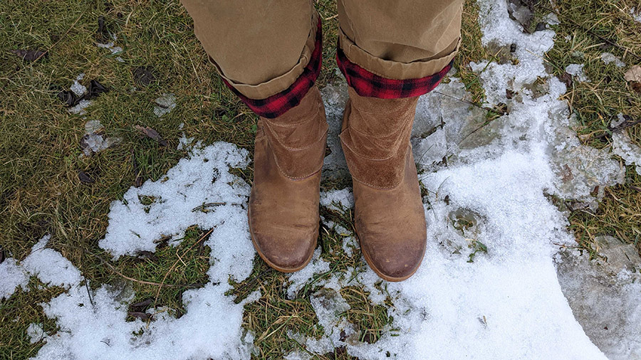 Person wearing boots on a snowy lawn