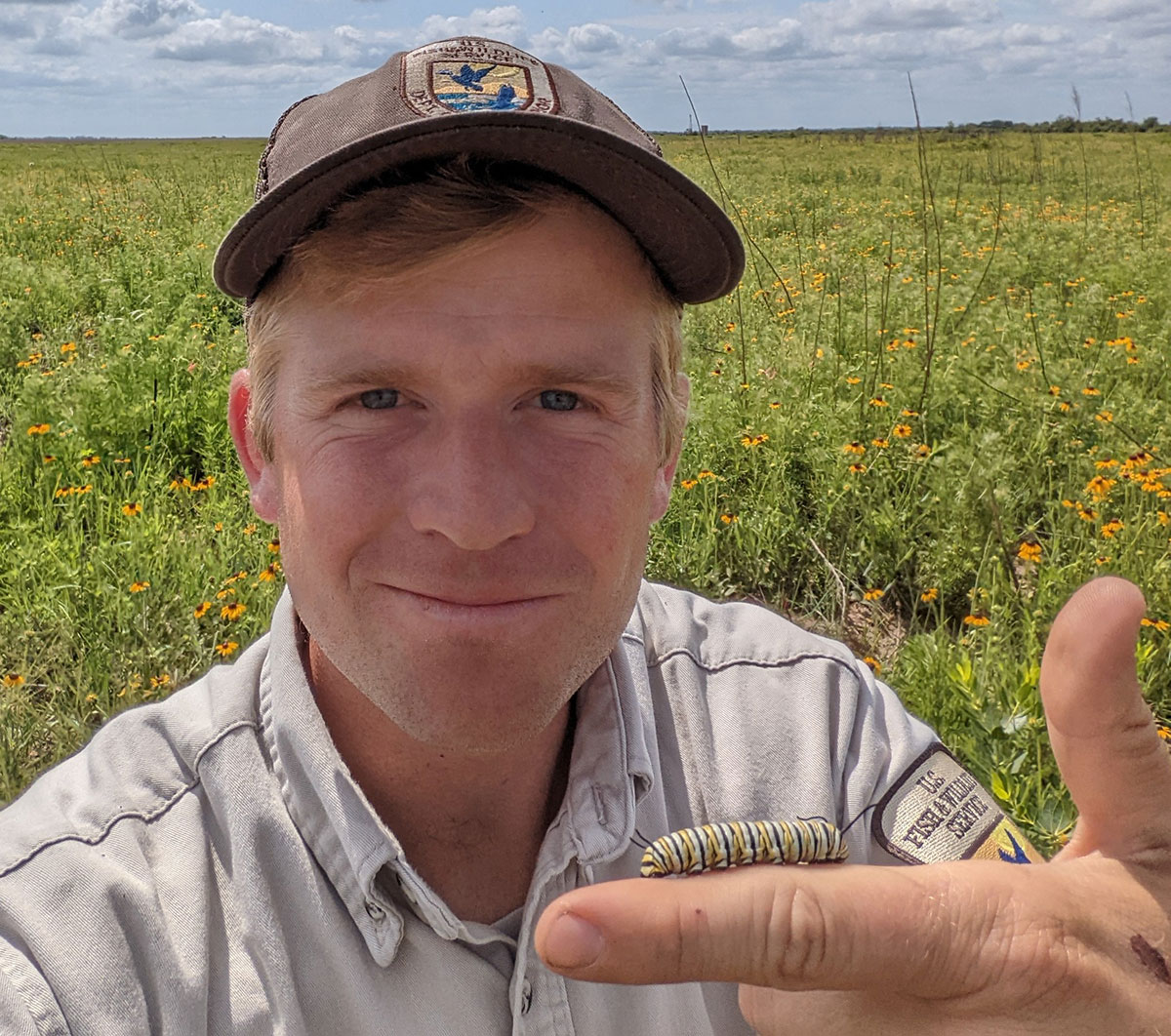 Remy Sutherland with monarch caterpillar on finger