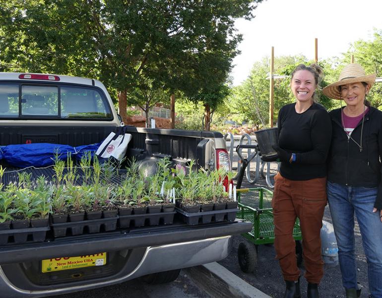 Folks standing next to a truck bed full of nursery plants