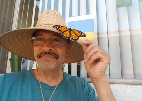 Xerces Society member Augustin Garnier with monarch butterfly on hat
