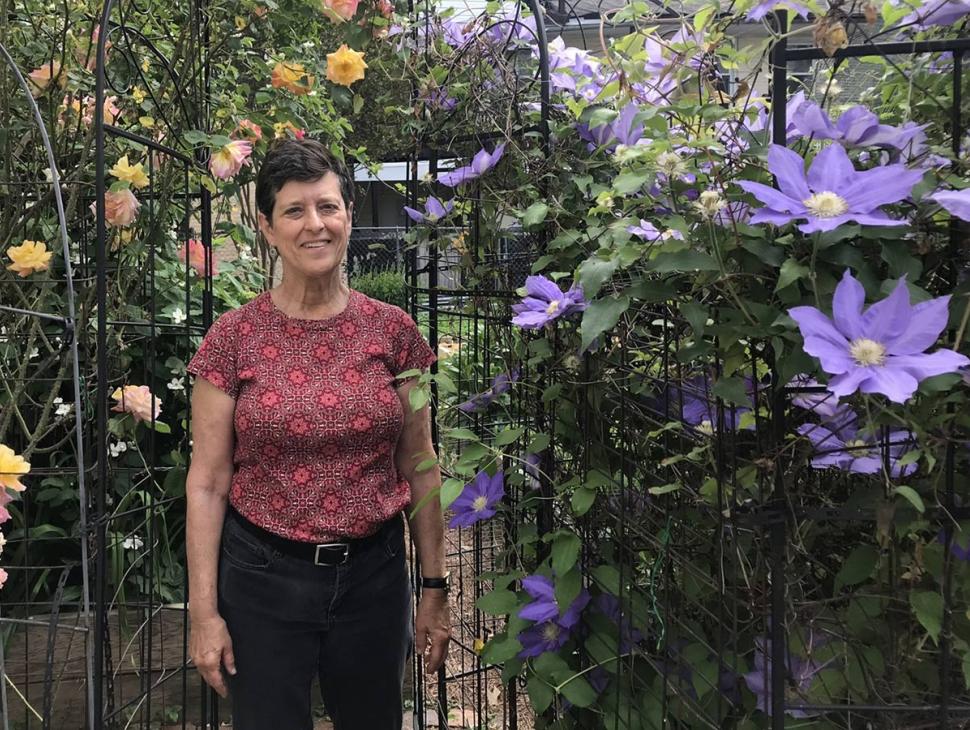 Jan Mooney standing by blooms in the garden
